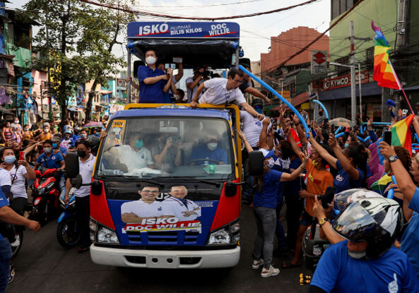 Image Source: Manila Mayor Isko Moreno (white shirt) greets supporters during a motorcade in the capital city promoting his 2022 presidential campaign (2022) Benar News
